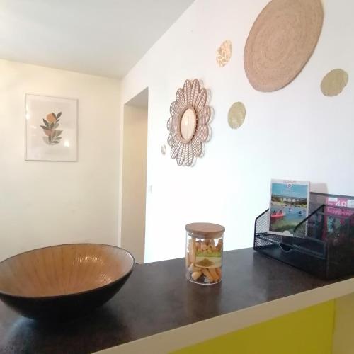 a counter with a bowl and a vase on it at Appartement 39 m2 Wifi parking gratuit proche Pont du Gard in Remoulins