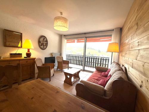 un salon avec un canapé et une grande fenêtre dans l'établissement Appartement calme avec balcon et vue montagne pour 4 pers - FR-1-515-227, à Villard-de-Lans