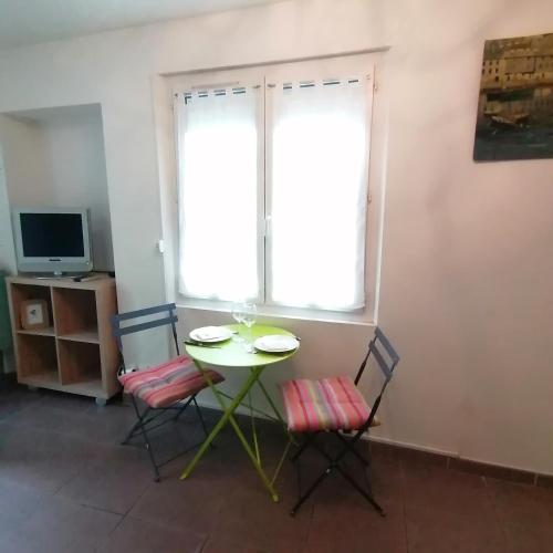 a table and two chairs in a room with a window at Appartement 39 m2 Wifi parking gratuit proche Pont du Gard in Remoulins