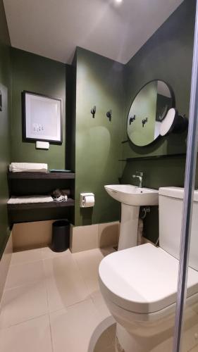 a bathroom with a white toilet and a sink at Highwind - Projector, Playstation 4, Pool in Silang