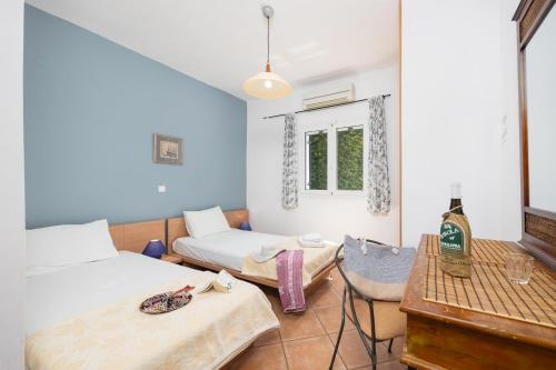 a room with two beds and a table at Villa Thalia Sofia in Mousata