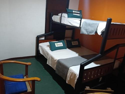 a room with two bunk beds and a chair at Biohotel Caribe Green in Santa Marta