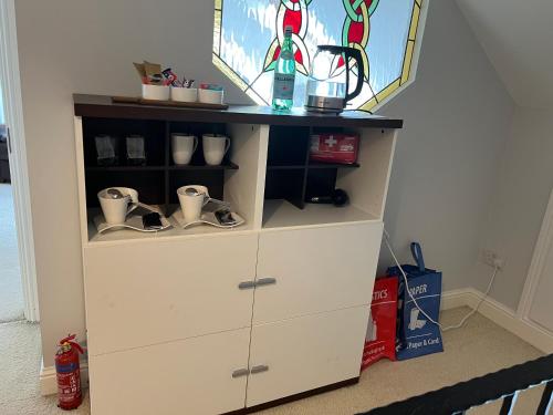 a white dresser with cups on top of it at Lake View Doubleroom&private Bath in Castlebar