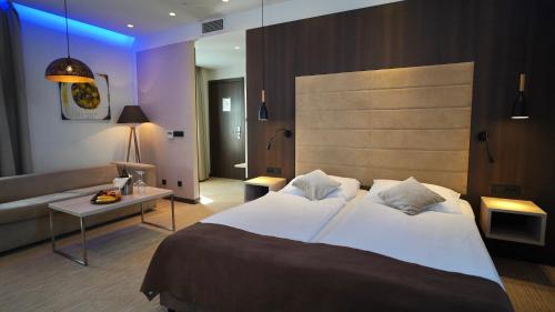 a hotel room with a large bed and a couch at Hotel Gallus in Sesvete