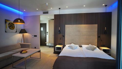 a bedroom with a large bed and a couch at Hotel Gallus in Sesvete