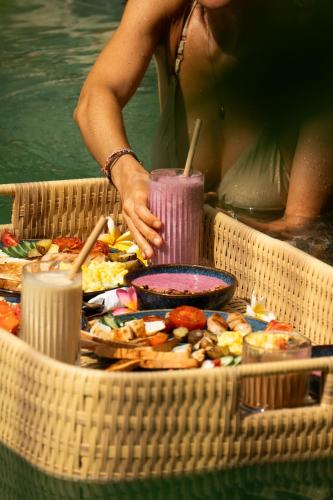 a woman standing next to a table filled with food at Villa Pantai - Signature Property in Gili Air
