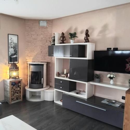 a living room with white shelves and a fireplace at La PERLA di LEVICO in Levico Terme