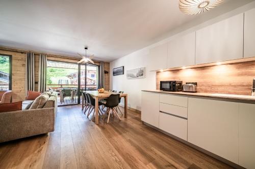 une cuisine et un salon avec une table et un canapé dans l'établissement Apartment Edelweiss Les Gets - BY EMERALD STAY, aux Gets
