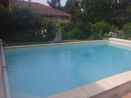 - une grande piscine avec 2 chaises dans la cour dans l'établissement Gîte de charme piscine, à La Celle-sous-Gouzon