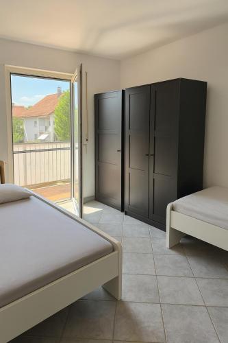 a bedroom with two beds and a sliding glass door at Monteur- und Ferienwohnung Rheinhausen - Lönsweg in Oberhausen-Rheinhausen