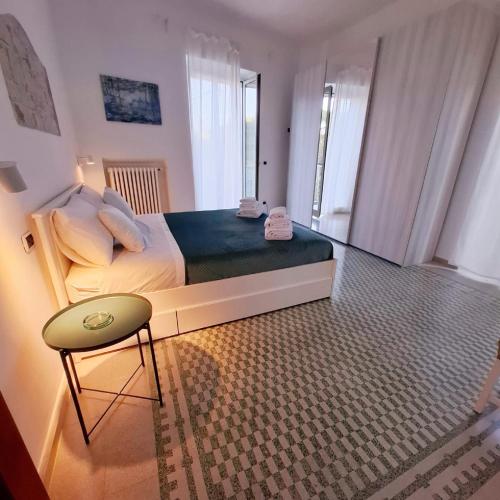 a bedroom with a large bed and a chair at Domus Nicolaus in Giovinazzo