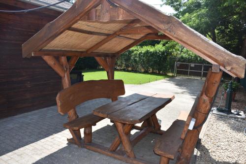 a wooden bench sitting in a wooden gazebo at Békafütty Vendégház in Ráckeve