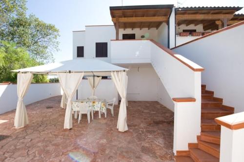 a patio with a white table and chairs and stairs at A Borgo Frigole 1 in Frigole