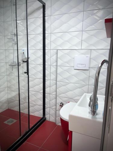 a bathroom with a shower and a toilet and a sink at Hotel Heimli in Pristina
