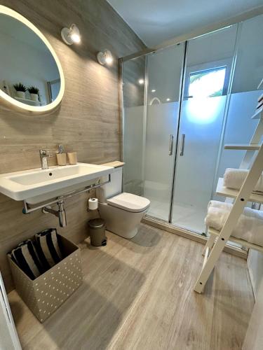 a bathroom with a sink and a toilet and a mirror at Apartamento Ciutadella con piscina en Son Xoriguer - Menorca in Son Xoriguer