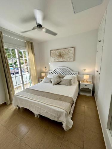 a bedroom with a large bed and a window at Apartamento Ciutadella con piscina en Son Xoriguer - Menorca in Son Xoriguer