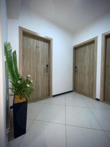 a hallway with two doors and a potted plant at Hotel Heimli in Pristina