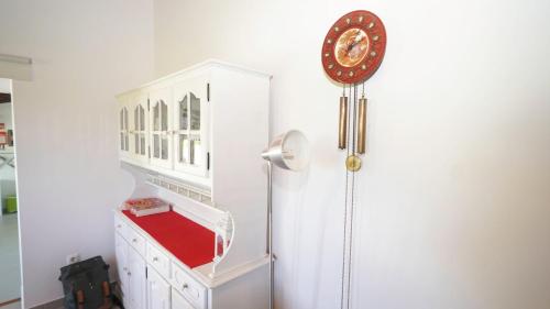 a clock on a wall next to a white cabinet at Monte dos Casarões Casa grande in São Luis