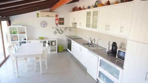 a kitchen with white cabinets and a white table at Monte dos Casarões Casa grande in São Luis