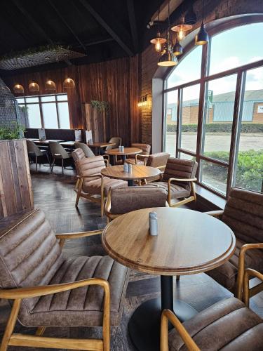 a restaurant with tables and chairs and windows at Hotel Nineteen in Barnsley