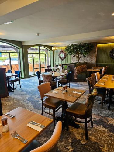 a restaurant with wooden tables and chairs and tables and tablesearcher at Hotel Nineteen in Barnsley