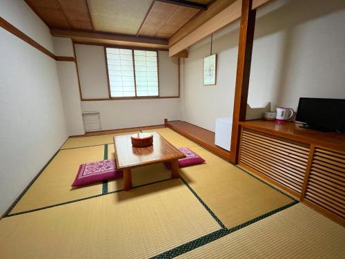a room with a table and a tv in it at Matsunoki-tei in Otari