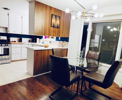 a kitchen with a glass dining table and chairs at The Mod Pod in Eugene