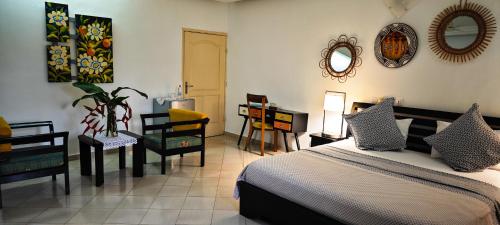 a bedroom with a bed and a table and chairs at Villa Oasis Abidjan in Abidjan