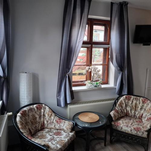 two chairs and a table in a room with a window at Willa REIMERS in Krynica Morska