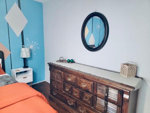 a bedroom with a dresser and a mirror on the wall at The Mod Pod in Eugene