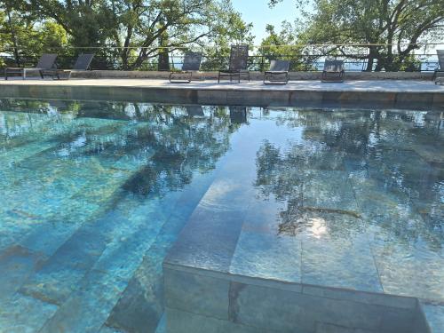 a swimming pool with a reflection of trees in the water at Domaine de la Mautanne in Sainte-Tulle