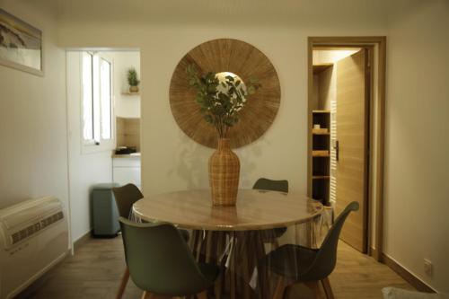 a dining room with a table with a vase on it at Le patio d'Elio, Arcachon in Arcachon