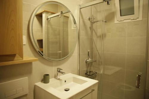 a bathroom with a sink and a shower with a mirror at Le patio d'Elio, Arcachon in Arcachon