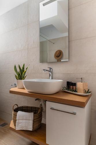 a bathroom with a sink and a mirror at Dimelli Luxury Suites in Ermioni