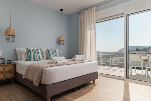 a bedroom with a large bed and a large window at Dimelli Luxury Suites in Ermioni