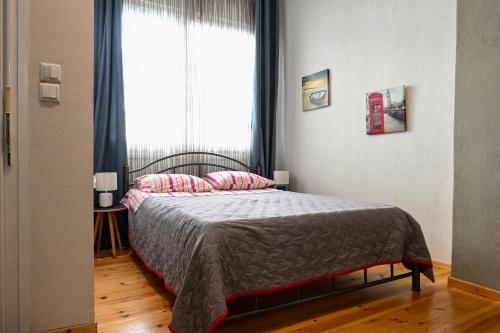a bedroom with a bed with pink pillows and a window at Penelope's and John's House in Kavála