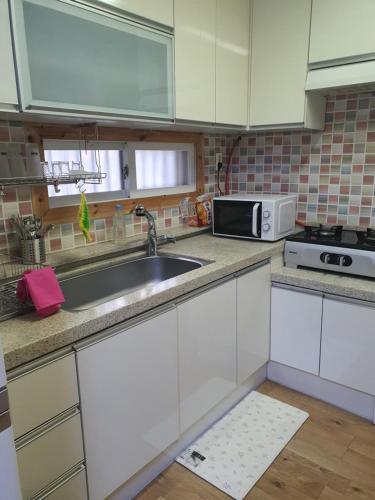 a kitchen with a sink and a microwave at Garden House in Daegu