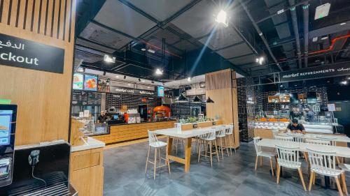 un restaurant avec des tables et des chaises dans une salle dans l'établissement Luxurios One Bedroom High Floor, à Dubaï