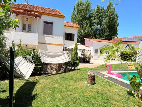 a house with a hammock and a swimming pool at Bam’s Farm in Alcobaça