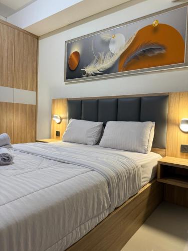 a bedroom with a large bed and a painting on the wall at Pollux studio Suite 2 by Superstay in Batam Center