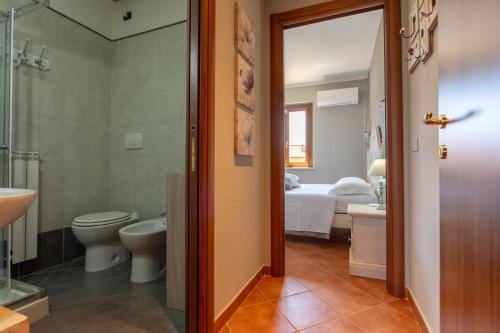 a bathroom with a toilet a sink and a bed at CS Holiday in Castelnuovo Berardenga