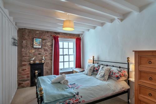 ein Schlafzimmer mit einem Bett und einem Fenster in der Unterkunft Finest Retreats - Rose Cottage, Kingsand in Kingsand
