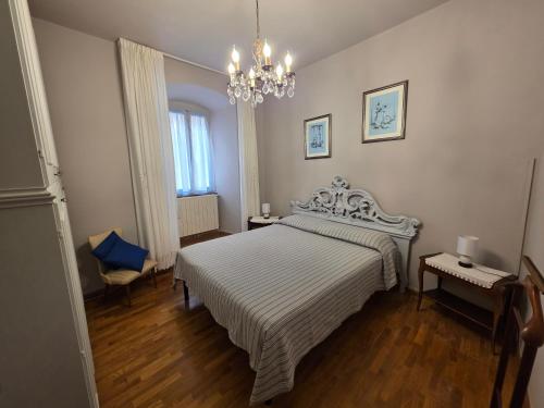 a bedroom with a white bed and a chandelier at Trevi al Centro in Trevi