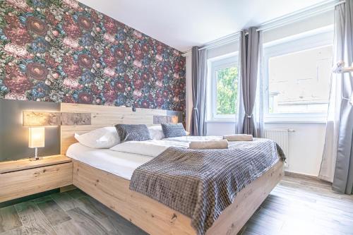 - une chambre avec un grand lit et un mur fleuri dans l'établissement 9 Min to Center, Modern 1BR & 1LR Apt with Balcony & Smart TV, à Vienne