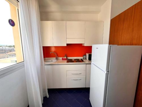 a kitchen with white cabinets and a white refrigerator at Residence Adriatico in Gabicce Mare