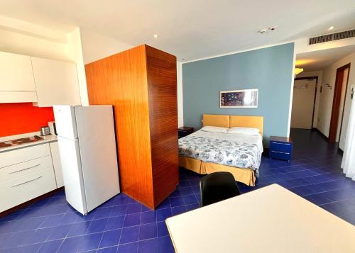 a small room with a bed and a refrigerator at Residence Adriatico in Gabicce Mare