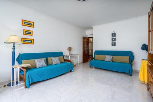 a living room with two blue couches and a lamp at Classic & Spacious Flat w/ Balcony by HostWise in Monte Gordo