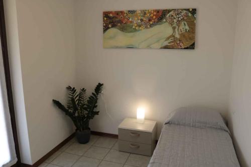 a bedroom with a bed with a lamp and a painting at Apartment Colà di Lazise - Gardasee 26307 in Colà di Lazise