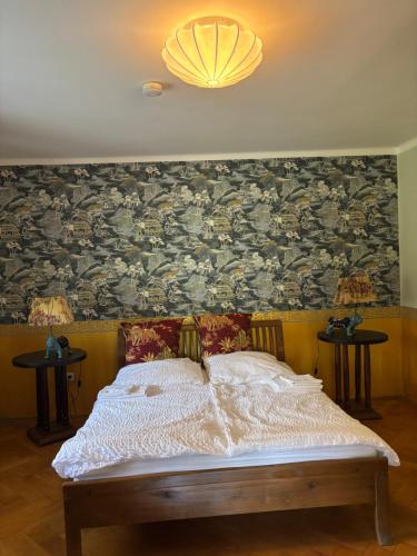 a bedroom with a bed and a wall with a wallpaper at Villa Vilma Antica in Laufen