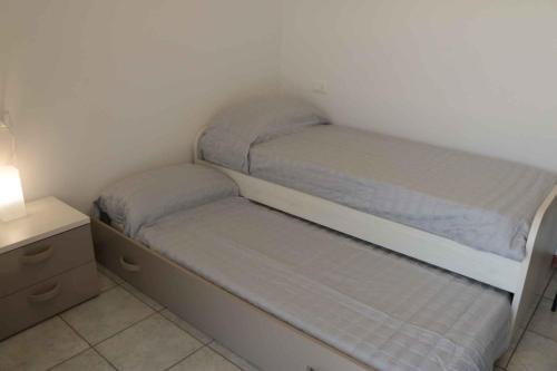 a small bedroom with two beds and a nightstand at Apartment Colà di Lazise - Gardasee 26307 in Colà di Lazise